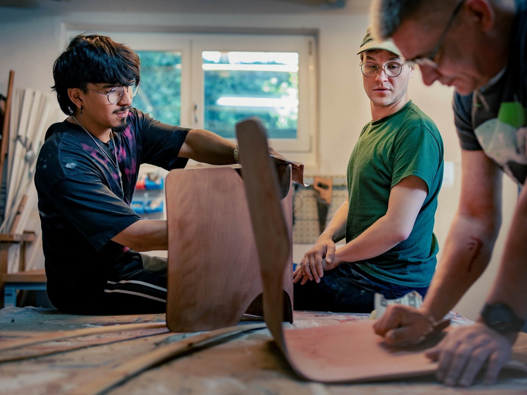 Schreinerei, in der Arbeitstherapie arbeiten drei Männer an verschiedenen Holzstühlen
